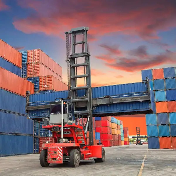 Reach stacker lifting a container between stacks in a container yard.
